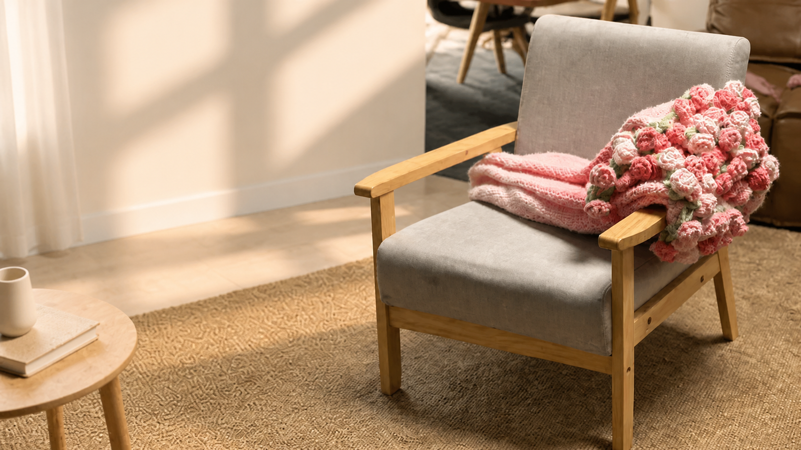 A handmade pink flower bouquet blanket resting on a chair in warm sunlight